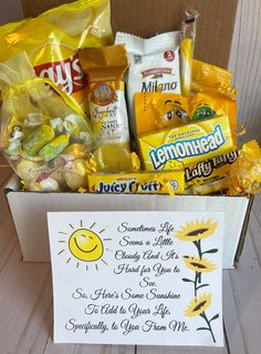 an open box filled with snacks and candy sitting on top of a wooden table next to a sign