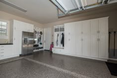 an empty kitchen with white cabinets and stainless steel refrigerator freezer next to the stove