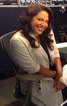 a woman sitting in a chair smiling at the camera