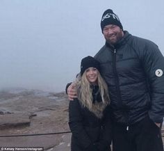 the man and woman are posing for a photo on top of a mountain in winter