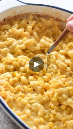 a person stirring macaroni and cheese in a pan