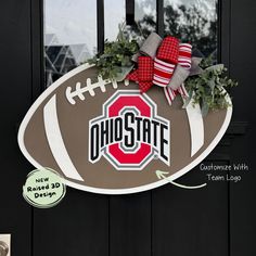 a football shaped door hanger with the word ohio on it and a red bow