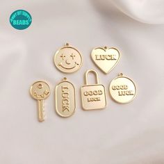 four charms that say luck, lock, good luck and love