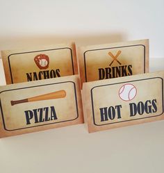 three wooden signs that say hot dogs, drinks, and baseballs are on display