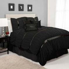 a bed with black comforter and pillows on display in a storefront advertizer