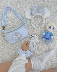 a person is laying on the floor next to some disney mouse ears and other items