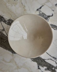 a white bowl sitting on top of a marble counter