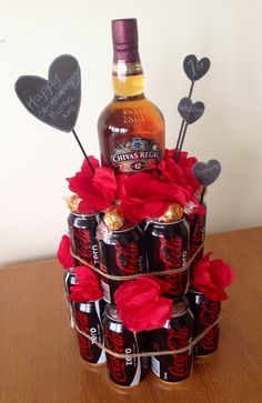 a cake made to look like it has been decorated with chocolates and roses, as well as a bottle of alcohol