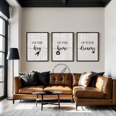 a living room with two brown leather couches and three framed pictures on the wall