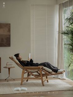 a woman sitting in a chair with her feet up on the floor and holding a remote control