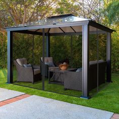 a gazebo sitting on top of a lush green field next to a patio area