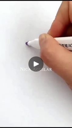 a person is writing on a piece of paper with a marker in their left hand