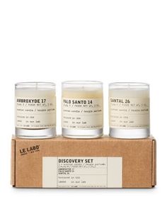 three candles sitting on top of a cardboard box with the label discovery set in it