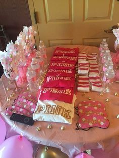 the table is set up with pink and gold decorations, water bottles, and other items