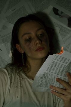 a woman is reading a book in the dark with her eyes closed and hands resting on top of an open book