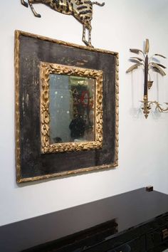 a painting hanging on the wall next to a mirror