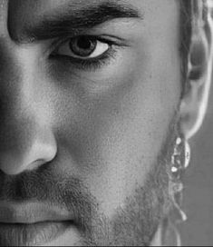 black and white photograph of a man's face with large hoop earrings on his ear