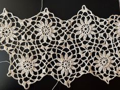 crocheted lace with flowers on black background