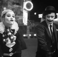 two people dressed up as clowns and one is wearing a top hat with polka dots