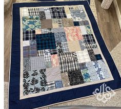 a blue and white patchwork quilt on the floor