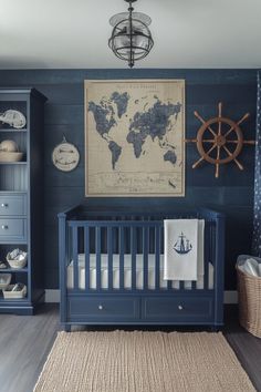 a baby's room with blue walls and wooden furniture, including a map on the wall