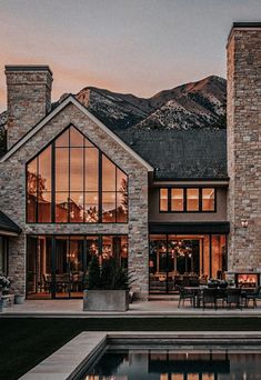 a large house with a pool in front of it and mountains in the back ground