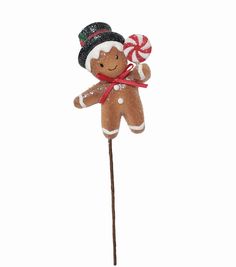 a gingerbread man on a stick with candy canes in its mouth and hat