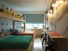 a bedroom with bunk beds and desks in front of a wall mounted poster on the wall