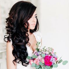 a woman with long black hair holding flowers