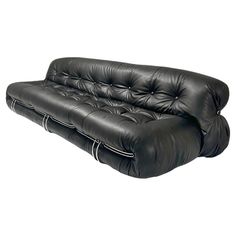 a black leather couch sitting on top of a white floor