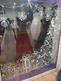 a window with christmas decorations and mannequins in it