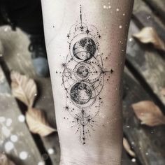 a woman's arm with a tattoo on it that has three planets and stars