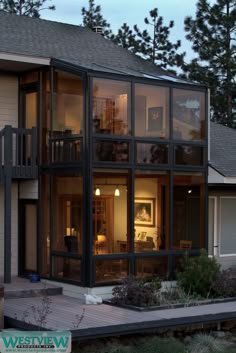 a large house with lots of windows on the front and side of it at night