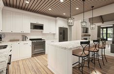 a large kitchen with white cabinets and wood flooring, along with an island in the middle