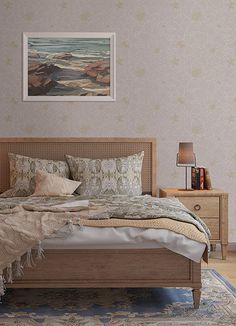 a bedroom with a bed, nightstands and pictures on the wall above it in front of a window