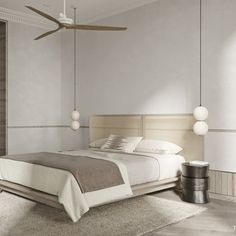 a bedroom with a bed, ceiling fan and two lamps hanging from the ceiling above it