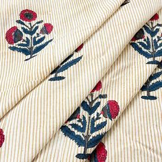 an up close shot of a fabric with red flowers on white and blue striped material