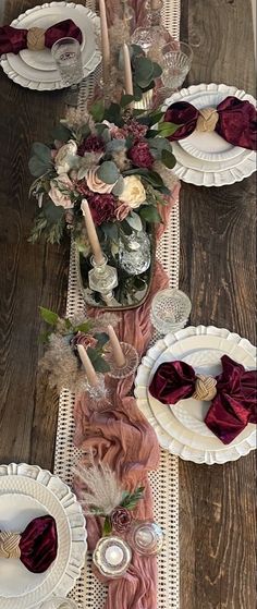 the table is set with white plates and red napkins