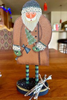 an old man with a beard and mustache is standing on top of a wooden table