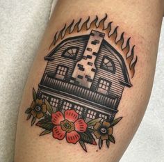 a tattoo on the leg of a person with a house and flowers in front of it