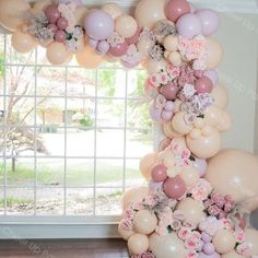 the balloon arch is decorated with pink, white and grey balloons that have flowers on them