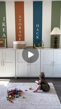 a toddler playing with toys on the floor in front of a wall painted with stripes