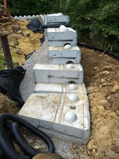 some concrete blocks sitting in the middle of a dirt field with a hose attached to them