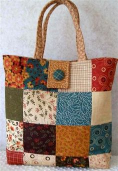 a multicolored patchwork tote bag sitting on top of a white table