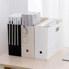 an office desk with a computer, glasses and file folders on top of it