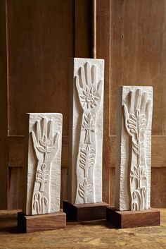 three white vases sitting on top of a wooden table