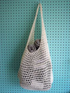 a bag hanging on the wall with balls of yarn in it