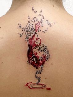 the back of a woman's neck with musical notes and a wine glass on it