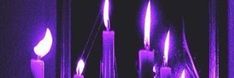 purple candles are lit up in the dark