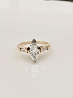 a gold ring with a pear shaped diamond